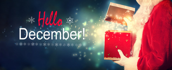 Hello December message with Santa opening a gift box on a shiny light background © Tierney