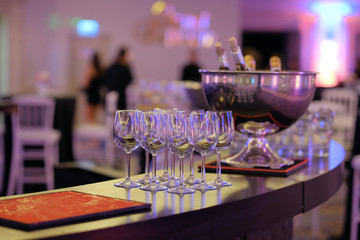 Bottle of champagne in bucket of ice. Bar counter.
