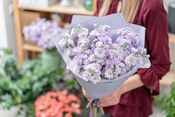 European floral shop. Two Bouquet of beautiful lilac flowers in woman hand. Excellent garden flowers in the arrangement , the work of a professional florist.
