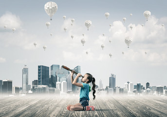 Concept of careless happy childhood with girl looking in spyglas
