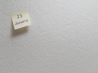 January 23: Calendar date on a yellow sticky note with copy space on white background.