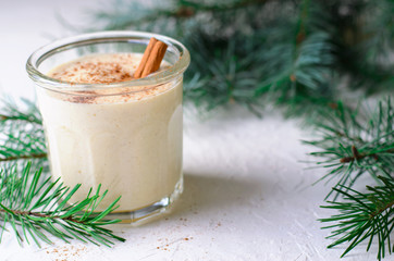 Obraz na płótnie Canvas Eggnog, Traditional Christmas Drink, Cocktail with Cinnamon and Nutmeg for Winter Holidays