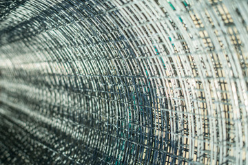 Fototapeta premium metal mesh twisted into a roll, close-up, as a background and abstraction