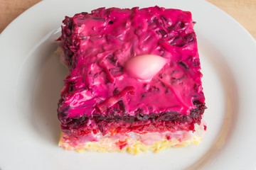 Dressed herring or herring under a fur coat. Traditional Russian cuisine. Layered salad composed of diced pickled herring covered with layers of boiled grated vegetables and mayonnaise.