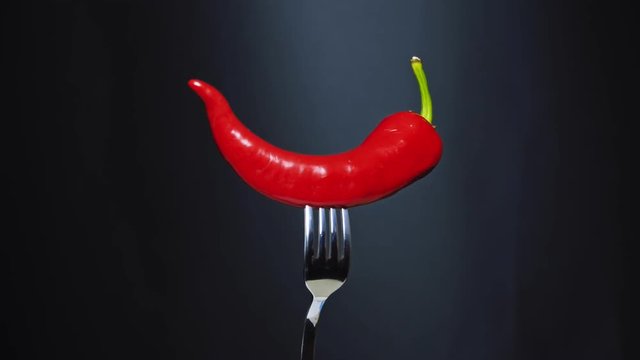 Red chili pepper on fork. 4k
