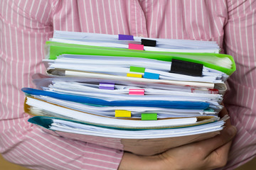 Stacks of documents in paper files in hands, business report documents. 