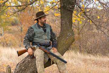 Hunter with a hat and a gun in search of prey in the steppe
