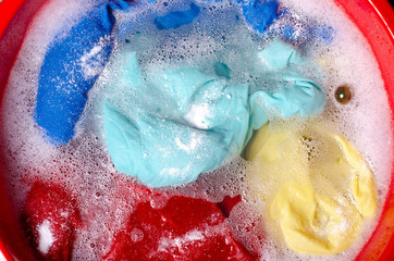 Fototapeta premium Washing color clothes in basin enemale powdered detergent, top view