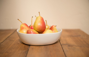 Pears in white bowl on wood