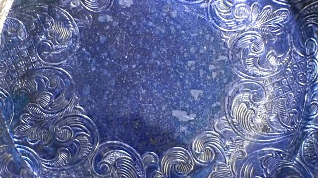 Background of rotaing silver tray in blue lighting