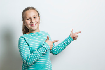 Girl on a white background shows fingers on copy space. 