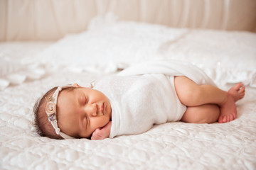 Cute newborn baby is sleeping on a big bed. Copy space and top view