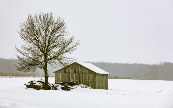 Antique barn in a snowy winter scene in rural Quebec, Canada.