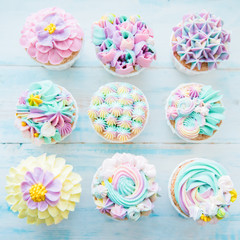 Many sweet birthday cupcakes with flowers and butter cream