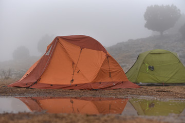 hiker tents in mountains in rain