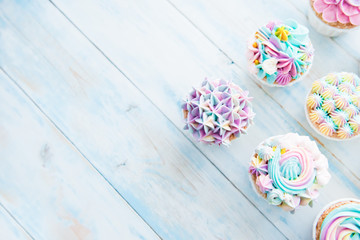 Many sweet birthday cupcakes with flowers and butter cream
