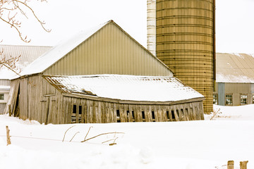Antique barn in a snowy winter scene in rural Quebec, Canada.