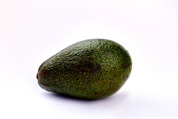 Whole avocado on light background. Close up green healthy avocado on grey background. Healthy lifestyle concept.