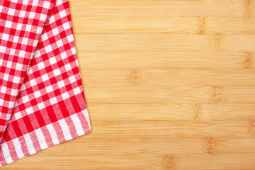Obraz premium Red checkered cloth on a wooden surface. Dining napkin. Kitchen towel