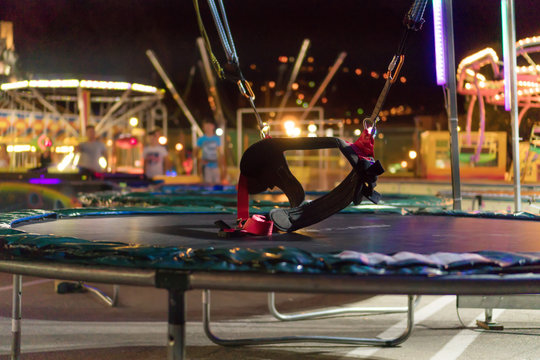 Bungee trampoline in amusement park at night.