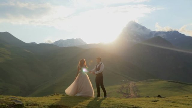 Beautiful video of a guy and a girl in a gorgeous dress in the mountains at sunset. Romantic unforgettable date