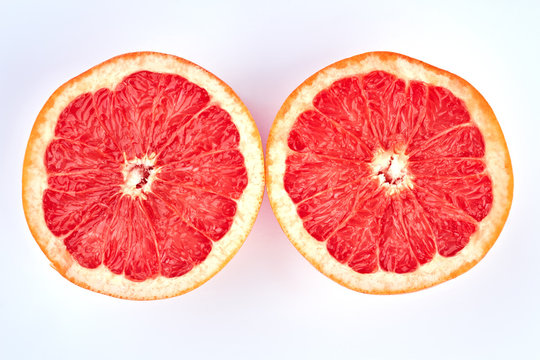 Two halves of juicy grapefruit. Ripe delicious grapefruit sliced on two parts on light background. Grapefruit for weight loss.