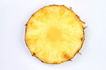 Slice of ripe pineapple on light background. Round pineapple slice. Nutritious exotic fruit.
