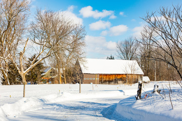Antique barn in rural Quebec Canada in a snowy seasonal background.