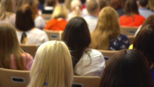 people at a conference or presentation, workshop, master class photograph. Back view. It is a lot of people.