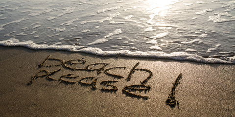 beach please written into the sand at sunny beach