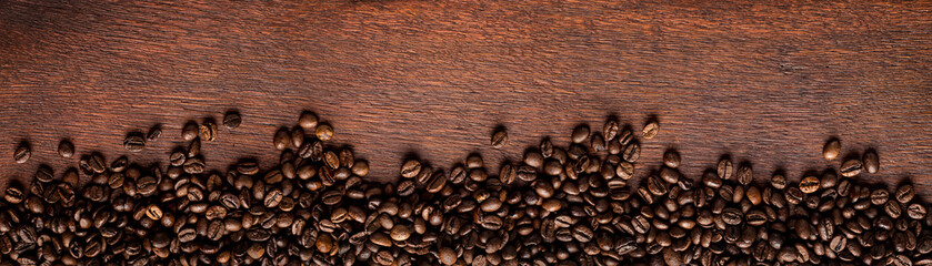 fresh roasted coffee beans on natural dark oak wood panorama background