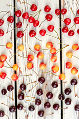 Ripe cherries background. Mix of delicious cherries on vintage wooden surface. Healthy eating concept.