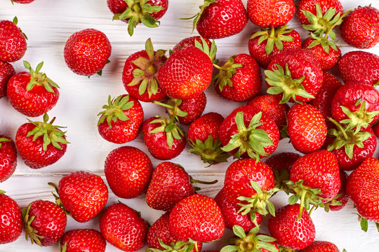 Ripe juicy strawberries background. Freshly harvested strawberries close up. Summer harvest of tasty berries.