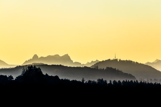 Faded misty hills and mountain range before sunrise, Mürtschenstoch and Bachtel