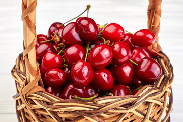 Close up basket filled with ripe cherries. Sweet juicy berries in basket close up. Healthy summer fruit.
