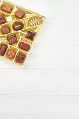 Group of chocolate candies in box. Assortment of delicious chocolate candies and copy space, vertical image.