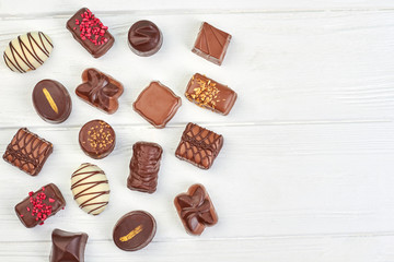 Assortment of chocolate candies and copy space. Variety of chocolate sweets on white background and text space.