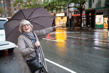 Mature senior white haired woman waiting for taxi cab in New York