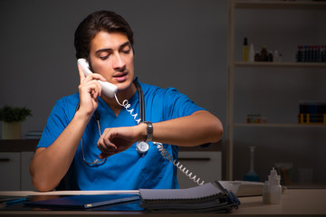 Young handsome doctor working night shift in hospital   