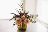 Roses in small gold vase with greens