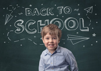 Adorable little boy with blackboard and back to school concept