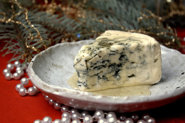 a piece of cheese with mold on a festive New Year's table selective focus.