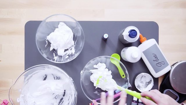 Step by step. Flat lay. Mother and daughter making colorful fluffy slime