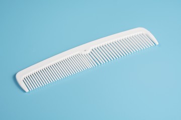 White hair comb isolated on blue background