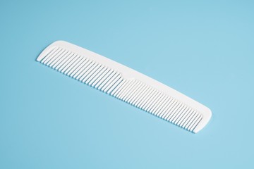 White hair comb isolated on blue background