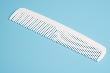 White hair comb isolated on blue background