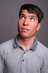Fototapeta premium Portrait of young Asian man against gray background