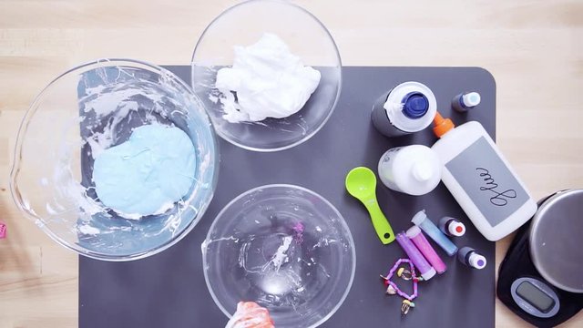 Step by step. Flat lay. Mother and daughter making colorful fluffy slime