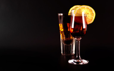 Red refreshing cocktail prepared by the bartender on a black background