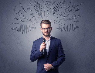 Businessman speaking into microphone with scribbles over his head 